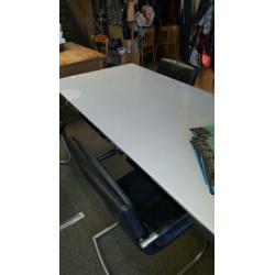 Tafel met wit glazen blad en RVS onderstel