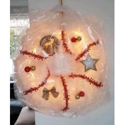 Kerstkransen te koop met verlichting.