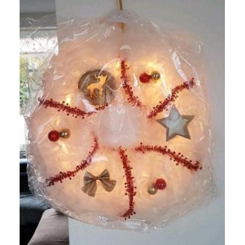 Kerstkransen te koop met verlichting.