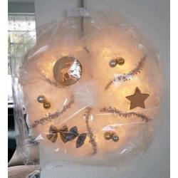 Kerstkransen te koop met verlichting.
